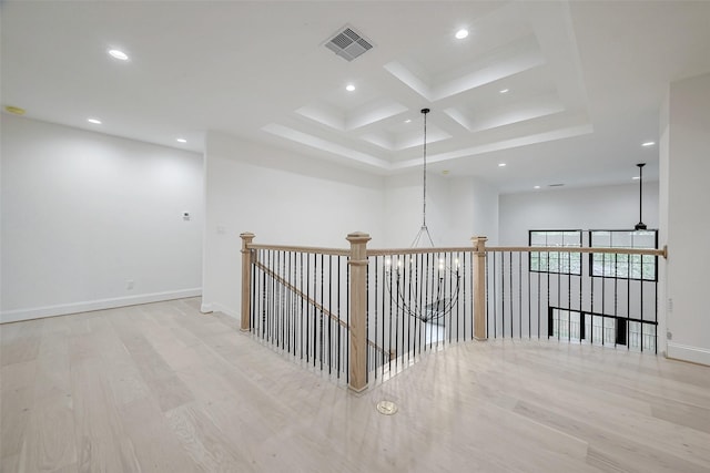 hall with coffered ceiling, light hardwood / wood-style flooring, and beamed ceiling