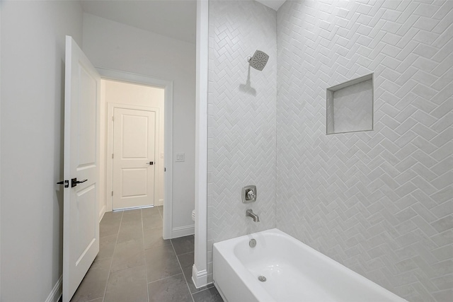 bathroom featuring tiled shower / bath combo, tile patterned floors, and toilet