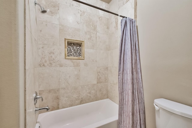 bathroom featuring shower / tub combo and toilet