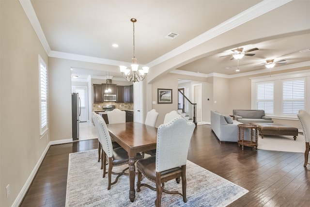 dining area featuring ornamental molding, dark hardwood / wood-style floors, and ceiling fan with notable chandelier