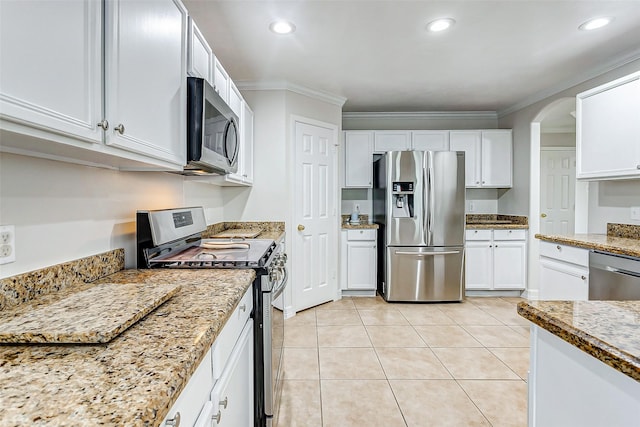 kitchen featuring crown molding, appliances with stainless steel finishes, light stone counters, and white cabinets