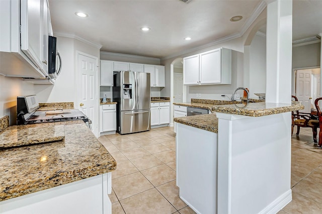 kitchen featuring light tile patterned flooring, stainless steel appliances, light stone countertops, and white cabinets