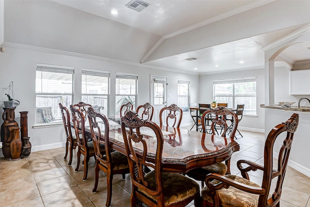 dining space featuring lofted ceiling, ornamental molding, and light tile patterned floors