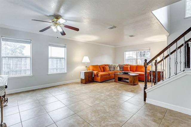 living room featuring light tile patterned flooring, ceiling fan, crown molding, and a textured ceiling