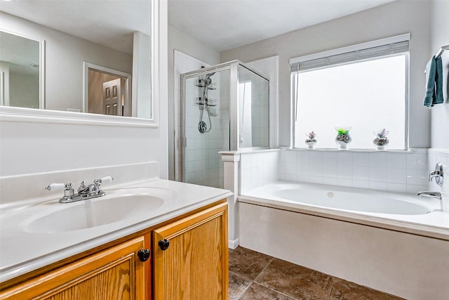 bathroom with vanity and shower with separate bathtub