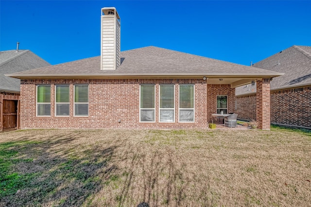 rear view of house with a patio and a lawn