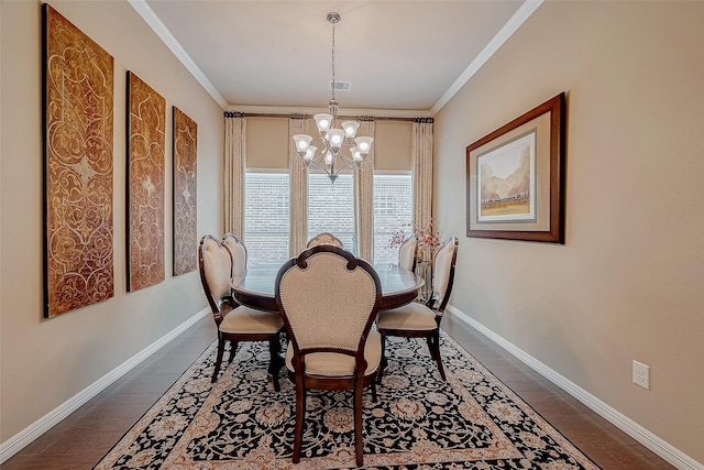 dining space with dark wood-type flooring, ornamental molding, and a chandelier