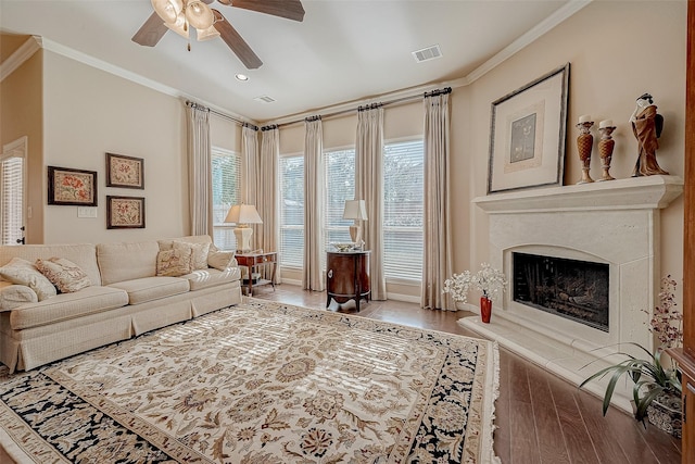 living room with hardwood / wood-style flooring, ornamental molding, and plenty of natural light