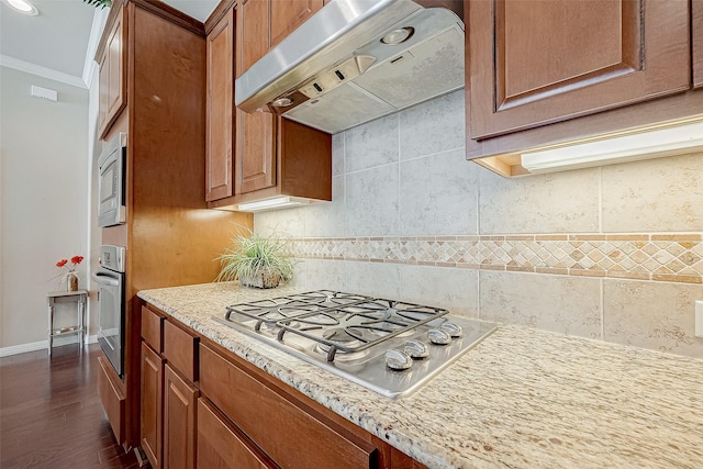 kitchen with extractor fan, tasteful backsplash, crown molding, appliances with stainless steel finishes, and dark hardwood / wood-style floors