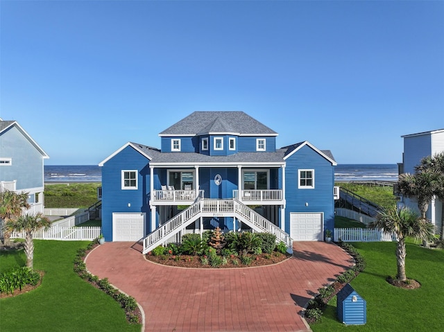 view of front of property with a garage, a water view, and covered porch