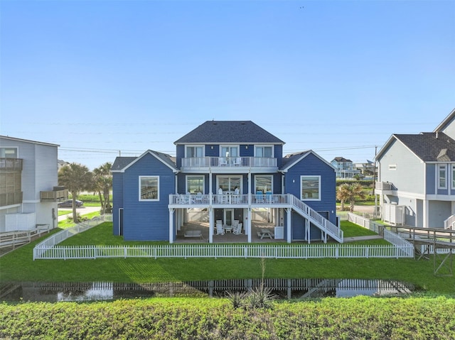 rear view of house with a lawn and a balcony