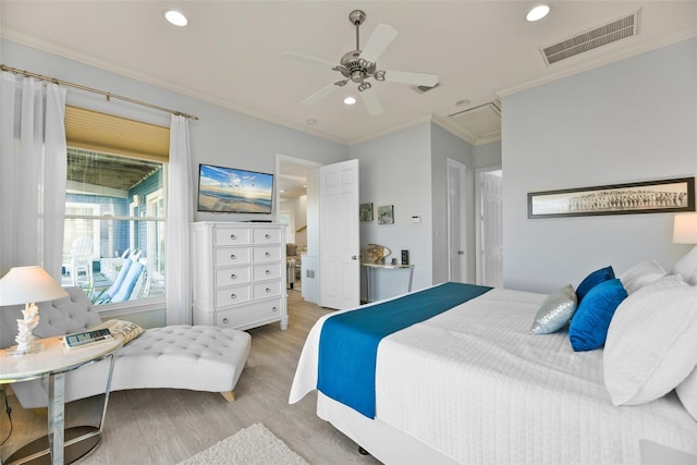 bedroom featuring ensuite bath, light hardwood / wood-style flooring, ornamental molding, and ceiling fan