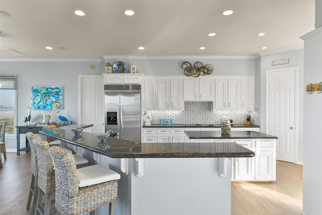 kitchen with white cabinetry, stainless steel built in fridge, and a large island