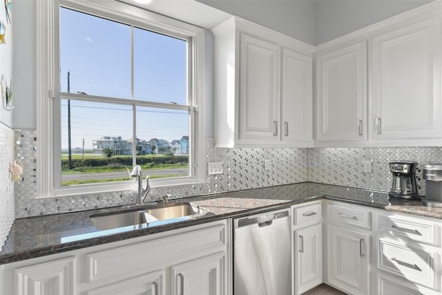 kitchen with white cabinetry, sink, stainless steel dishwasher, and dark stone counters