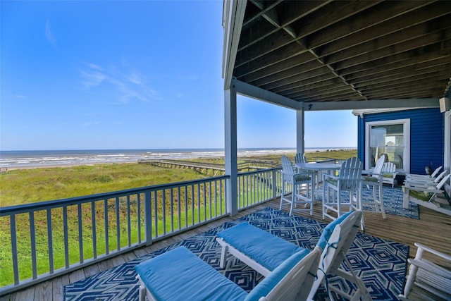 deck with a view of the beach and a water view