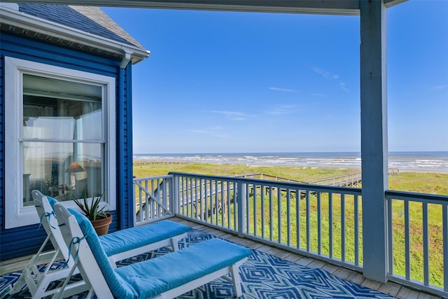 balcony featuring a beach view and a water view