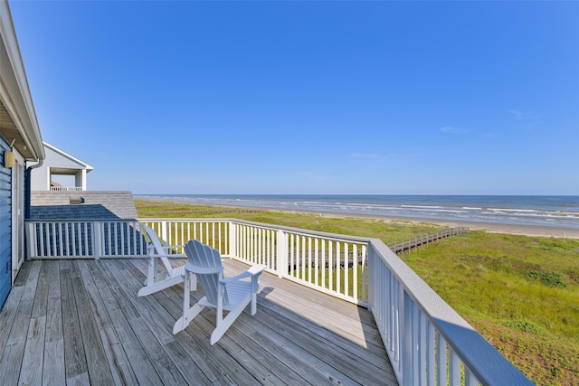 wooden terrace with a water view and a view of the beach