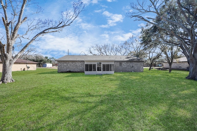 rear view of property with a sunroom and a lawn