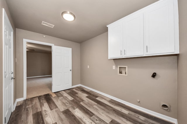 laundry room with gas dryer hookup, dark wood-type flooring, electric dryer hookup, cabinets, and washer hookup