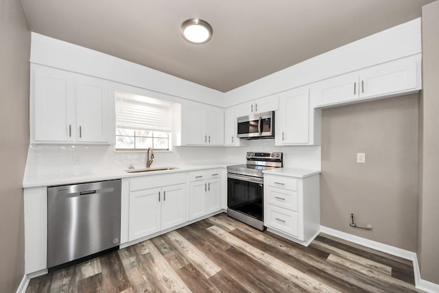 kitchen featuring stainless steel appliances, white cabinetry, sink, and dark wood-type flooring