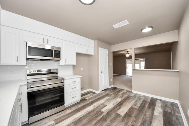 kitchen with white cabinetry, ceiling fan, stainless steel appliances, and hardwood / wood-style flooring