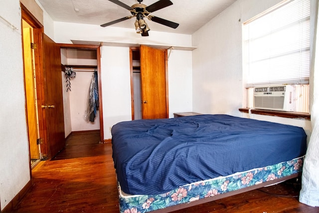 bedroom featuring cooling unit, ceiling fan, a closet, and dark wood-type flooring