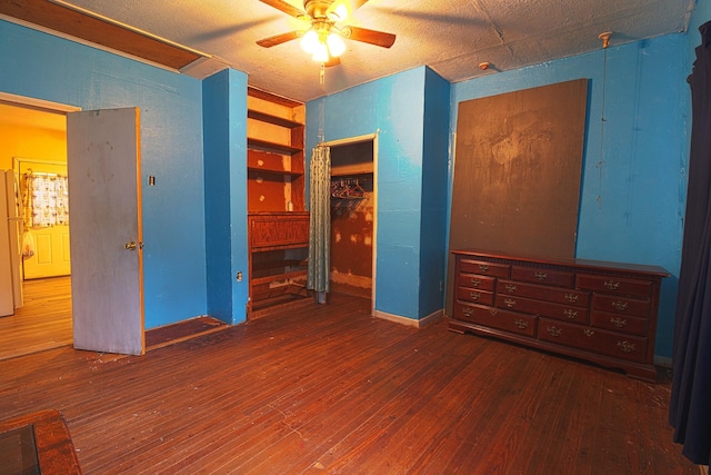 unfurnished bedroom featuring dark wood-type flooring, white refrigerator, and ceiling fan