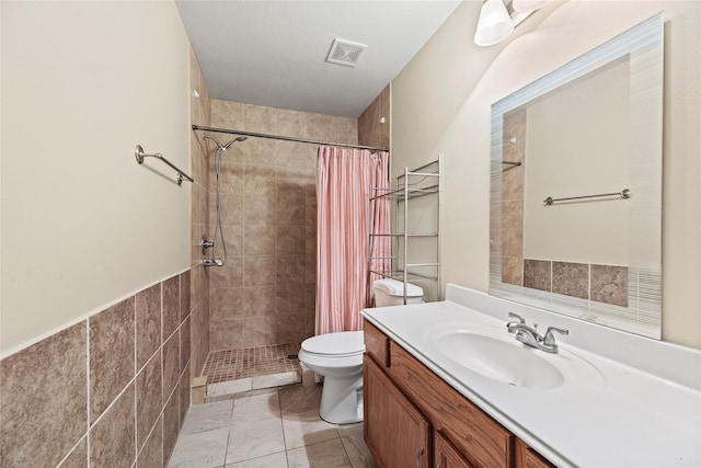 bathroom with vanity, curtained shower, tile patterned floors, and toilet