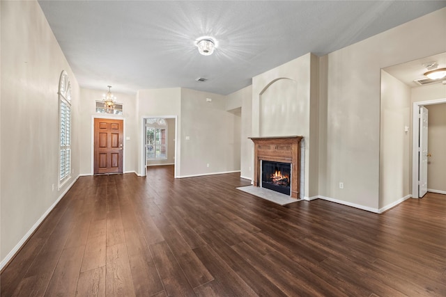 unfurnished living room with dark hardwood / wood-style floors and a notable chandelier