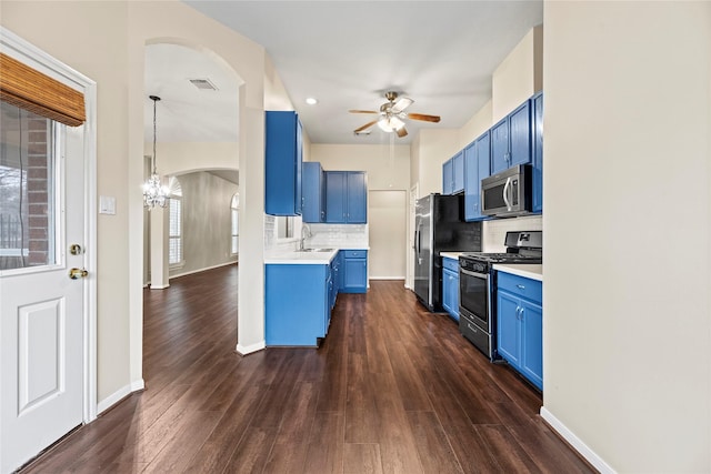 kitchen featuring stainless steel appliances, blue cabinetry, sink, and backsplash