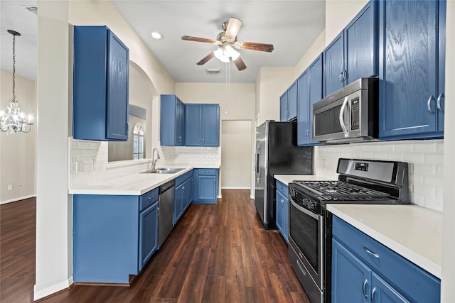 kitchen with blue cabinetry, sink, dark hardwood / wood-style flooring, pendant lighting, and stainless steel appliances