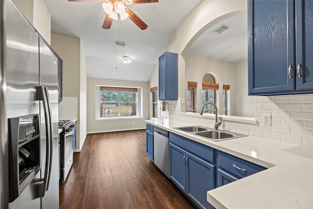 kitchen with sink, dark wood-type flooring, stainless steel appliances, blue cabinets, and decorative backsplash