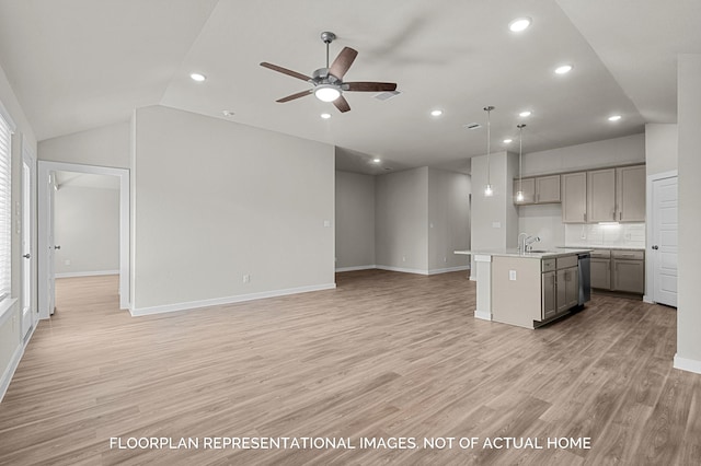 kitchen with open floor plan, light countertops, hanging light fixtures, gray cabinets, and a center island with sink