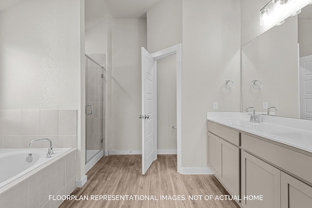 full bathroom featuring baseboards, wood finished floors, vanity, a shower stall, and a bath