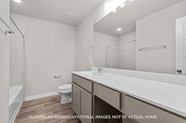 full bathroom with vanity, toilet, tiled shower / bath combo, and wood-type flooring