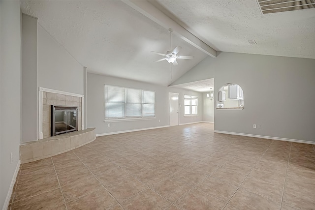 unfurnished living room with lofted ceiling with beams, a textured ceiling, light tile patterned floors, ceiling fan, and a fireplace