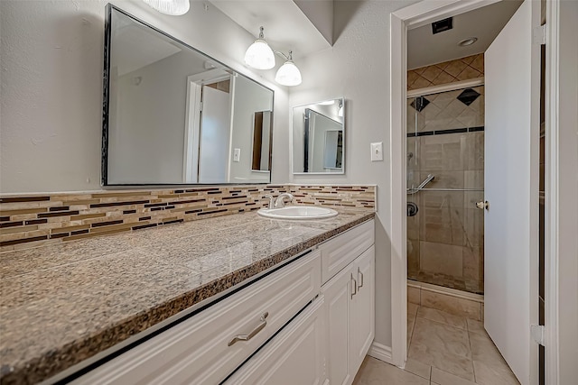 bathroom featuring tasteful backsplash, vanity, tile patterned flooring, and a shower with door