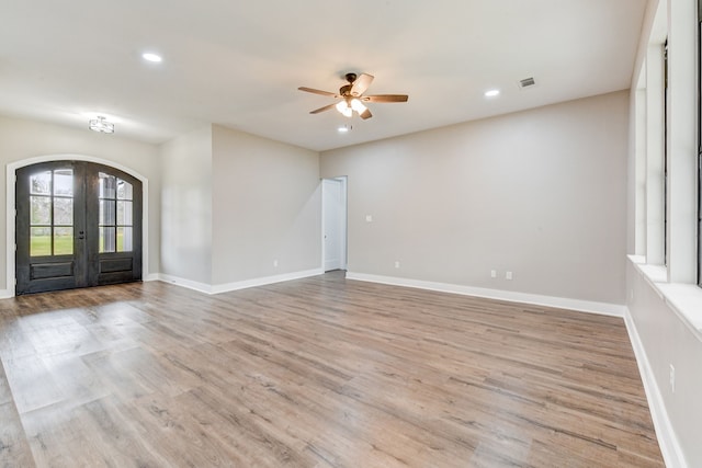 spare room featuring french doors, ceiling fan, and light wood-type flooring