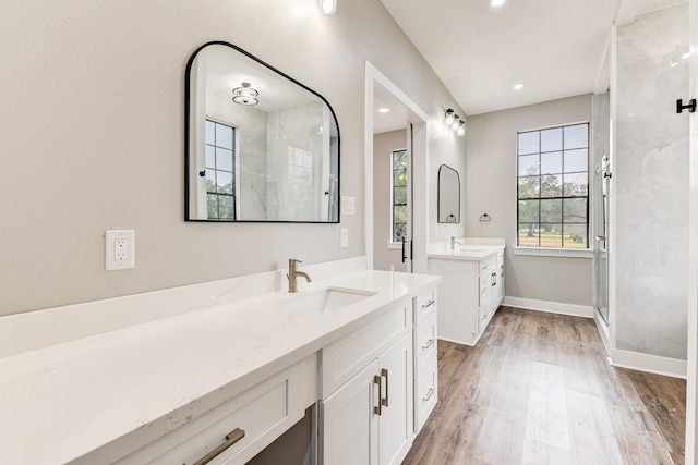 bathroom with hardwood / wood-style flooring, vanity, and walk in shower