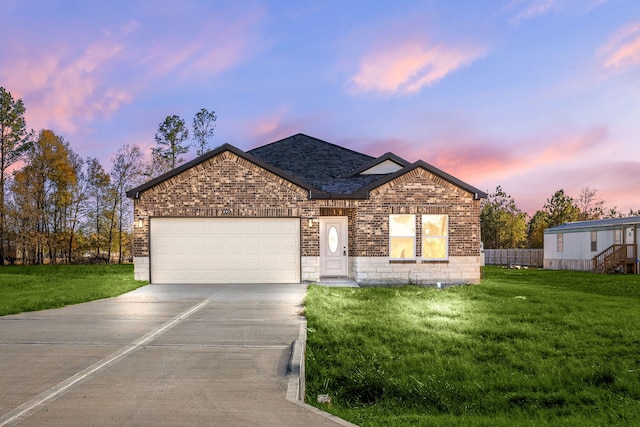 view of front of home with a garage and a lawn