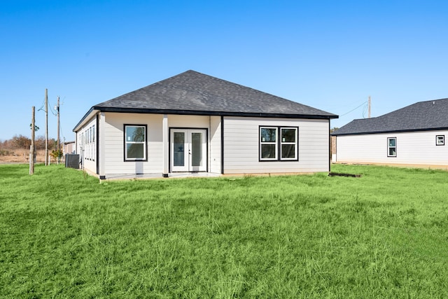 rear view of house featuring central AC, french doors, and a lawn