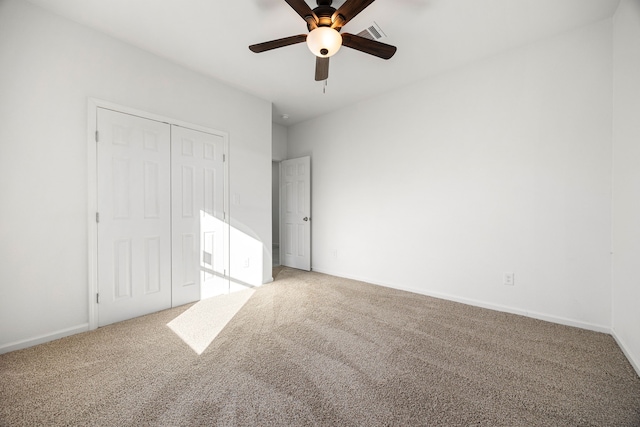 unfurnished bedroom with carpet floors, ceiling fan, and a closet