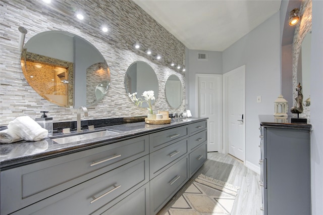 bathroom with tasteful backsplash, vanity, and hardwood / wood-style flooring