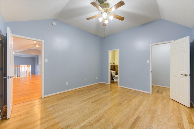 unfurnished bedroom featuring vaulted ceiling, connected bathroom, ceiling fan, and light hardwood / wood-style floors