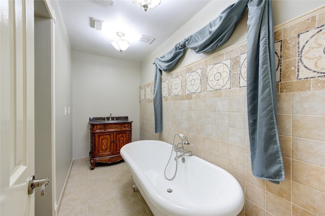 bathroom featuring tile patterned flooring, a washtub, and tile walls