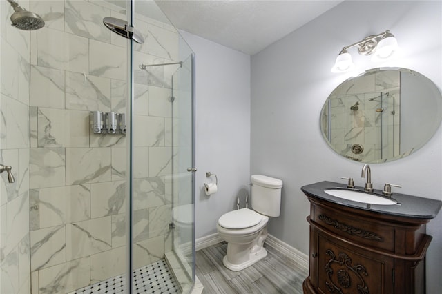 bathroom featuring vanity, toilet, and a shower with door