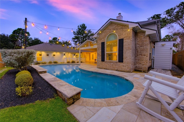 pool at dusk featuring a patio area