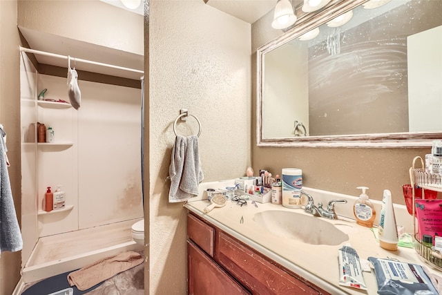 bathroom with vanity, toilet, and walk in shower