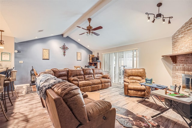 living room with vaulted ceiling with beams, light hardwood / wood-style flooring, a fireplace, and ceiling fan