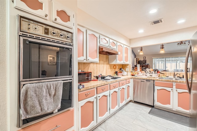 kitchen with sink, white cabinetry, stainless steel appliances, light tile patterned flooring, and decorative backsplash